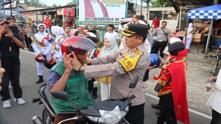 Edukasi Tertib Berlalu Lintas, Polres Pasbar Bagi Helm Gratis ke Pengendara 1 Kepala Polres Pasaman Barat AKBP Agung Tribawanto saat memasangkan helm gratis ke salah satu pengendara sepeda motor di Bundaran Simpang Empat sebagai upaya mengedukasi masyarakat tertib berlalu lintas, Kamis (14/3/2024). Antara/HO-Humas Polres Pasaman Barat.