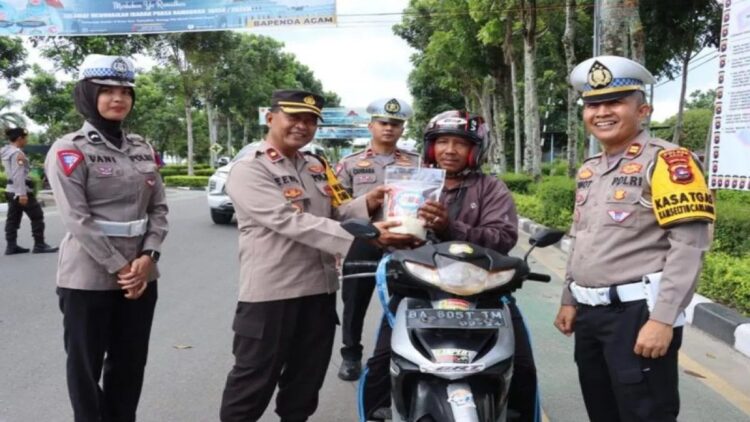 Satlantas Polres Agam Bagikan Ratusan Sembako untuk Pengendara 1 Wakapolres Agam Kompol Elvi Rinaldi didampingi Kasat Lantas Polres Agam Iptu Pifzen Finot membagikan sembako. Dok HO/Humas Polres Agam