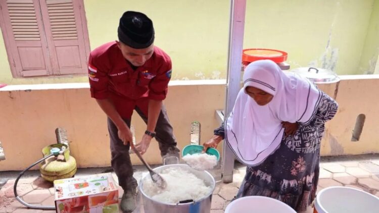 Seorang anggota tagana bersama warga menanak nasi di dapur umum Nagari (Desa) Ganting Mudik Utara Surantih, Kecamatan Sutera Kabupaten Pesisir Selatan, Kamis (14/3/2024). ANTARA/Muhammad Zulfikar.