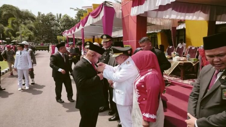 Bupati Agam Andri Warman menyerahkan penghargaan Satyalancana Karya Satya kepada Sekda Agam Edi Busti, Sabtu (17/8). Dok Antara/Yusrizal