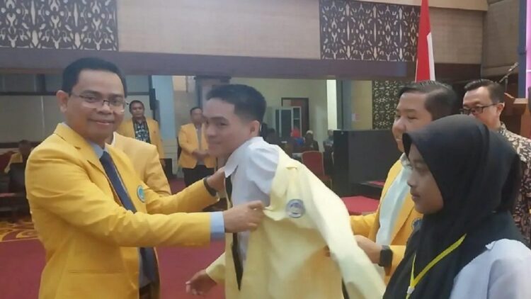 Terima 12.023 Mahasiswa Baru, Rektor UNP Tegaskan tak Ada Kenaikan UKT 1 Rektor Universitas Negeri Padang (UNP), Krismadinata memasangkan jaket almamater kepada mahasiswa baru UNP dalam kegiatan PKKMB gugus II, di auditorium UNP Air Tawar Padang, Rabu, (14/8). (Antara)