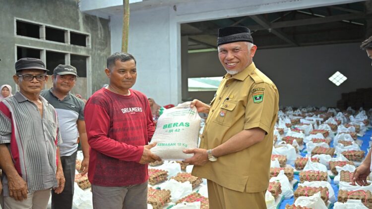 Gubernur Sumbar Mahyeldi menyerahkan bantuan beras kepada warga. (Foto: Dok. Diskominfotik Sumbar)