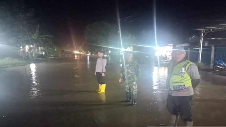 Anggota Polsek Palembayan dan TNI sedang mengatur arus lalu lintas terdampak banjir di Muaro Kandang, Nagari atau Desa Salareh Aia Barat, Kecamatan Palembayan, Kabupaten Agam, Sabtu (12/10) malam. Dok HO/Polres Agam