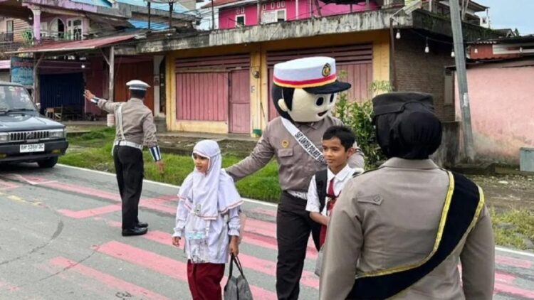 Petugas Kepolisian Polres Solok Selatan menggunakan seragam badut membantu pelajar menyeberangi jalan, Senin. (Foto: Antara)