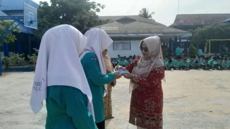 Kadisdukcapil Kota Solok Ratnawati saat menyerahkan KTP elektronik ke sejumlah siswa di SMA Kota Solok, Sumatera Barat. ANTARA/HO-Diskominfo Kota Solok.