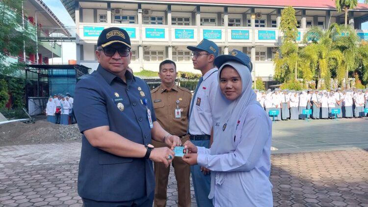 Pemko Padang Ajak Pelajar Berpartisipasi di Pilkada 2024 1 Pj Wako Padang menyerahkan e-KTP untuk pelajar. (Foto: Dok. Diskominfo Padang)