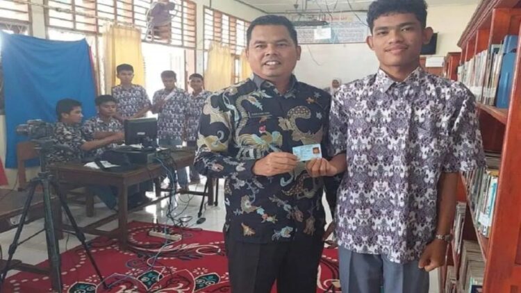 Kepala Bidang Pendaftaran Penduduk Dinas Kependudukan Catatan Sipil Pasaman Barat Harisantoni (kiri) saat melakukan perekaman KTP elektronik terhadap pemilih pemula disalah satu sekolah di daerah itu. (Antara/HO-Disdukcapil Pasaman Barat).