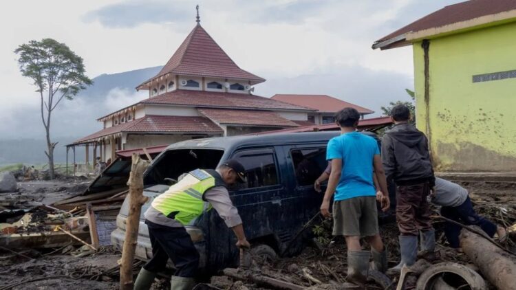 Pemprov Sumbar Maksimalkan Penggunaan EWS Cegah Dampak Banjir Lahar Dingin Marapi 1 Sejumlah warga dibantu personel kepolisian berusaha memindahkan mobil yang terseret banjir lahar dingin di Kabupaten Agam pada 15 Mei 2024. (ANTARA/Muhammad Zulfikar)