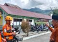 Kepala Desa Bukik Batabuah, Firdaus bersama petugas Basarnas dengan latar belakang Gunung Marapi tertutup awan. Sebanyak 1.300 jiwa di sekitar puncak Gunung Marapi masih beraktivitas normal hingga saat ini.(Antara/Al Fatah)