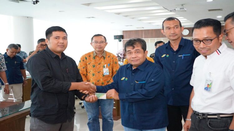 Region Head PTPN IV Regional 4, Ospin Sembiring, menyerahkan kartu bukti peserta BPJS Ketenagakerjaan kepada perwakilan orangtua anak penderita stunting. (Foto: Dok. Istimewa)