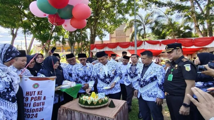 Wakil Bupati Pasaman Barat Risnawanto memotong tumpeng pada peringatan Hari Ulang Tahun ke-79 Persatuan Guru Republik Indonesia (PGRI) di Simpang Empat, Rabu (18/12/2024). ANTARA/Altas Maulana.