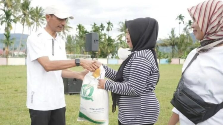 Wakil Bupati Solok Selatan Yulian Efi menyerahkan bantuan pangan kepada masyarakat penerima manfaat di Koto Parik Gadang Diateh, Minggu. (Antara)