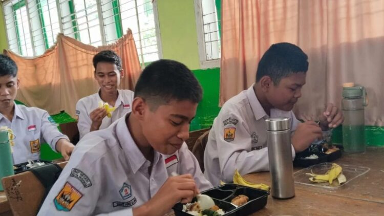 Sejumlah siswa SMPN 2 Pariaman, Sumbar terlihat menikmati makanan bergizi gratis. (ANTARA/Aadiaat M. S.)
