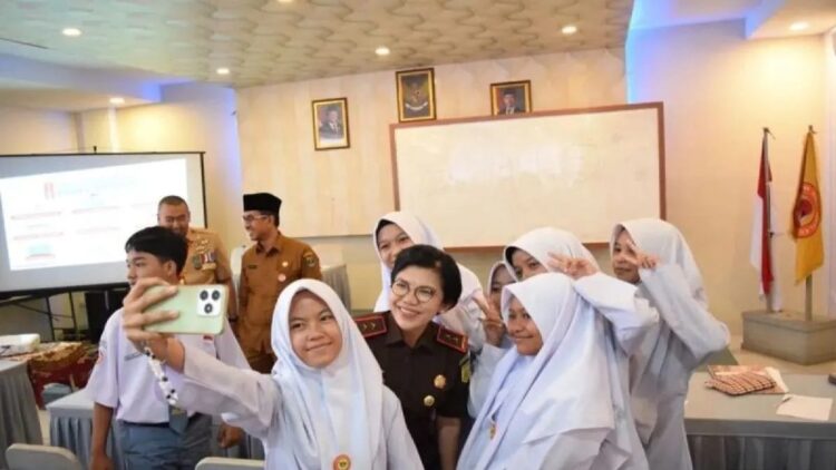 Kajati Sumbar Yuni Daru Winarsih berfoto bersama siswi SMKN 2 Padang usai peluncuran program Jaksa Mengajar di Padang, Senin (9/12). (Ist)