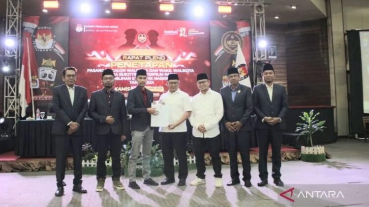 KPU Tetapkan Ramlan-Ibnu Resmi Jadi Wali Kota dan Wawako Bukittinggi 2025-2030 1 KPU Kota Bukittinggi menyerahkan surat keputusan penetapan Wali Kota dan Wakil Wali Kota terpilih Pilkada 2024 kepada Pasangan Ramlan Nurmatias dan Ibnu Asis (dok. Antara/Al Fatah)