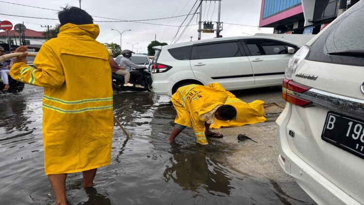 TRC Dinas PUPR Kota Padang membersihkan drainase yang tergenang air gegara hujan. (Foto: Ist)