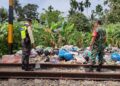 Petugas dari KAI Divre II Sumbar memeriksa kondisi ruas rel yang dijadikan tempat sampah.