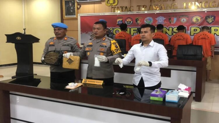 Kapolres Pasaman Barat AKBP Agung Tribawanto (tengah) didampingi Kasat Reskrim Narkoba Iptu Roni Surya Putra (baju putih) memperlihatkan barang bukti saat jumpa pers di Aula Mapolres setempat, Senin (10/2/2025). ANTARA/Altas Maulana) (Tangkap pengedar narkoba)