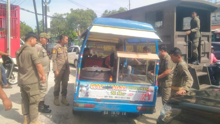 Sisir Kawasan Ramai PKL, Satpol PP Padang Amankan 10 Payung 1 Satpol PP Padang tertibkan PKL yang menggunakan fasum untuk berjualan di kawasan Simpang Haru. (dok. Humas)
