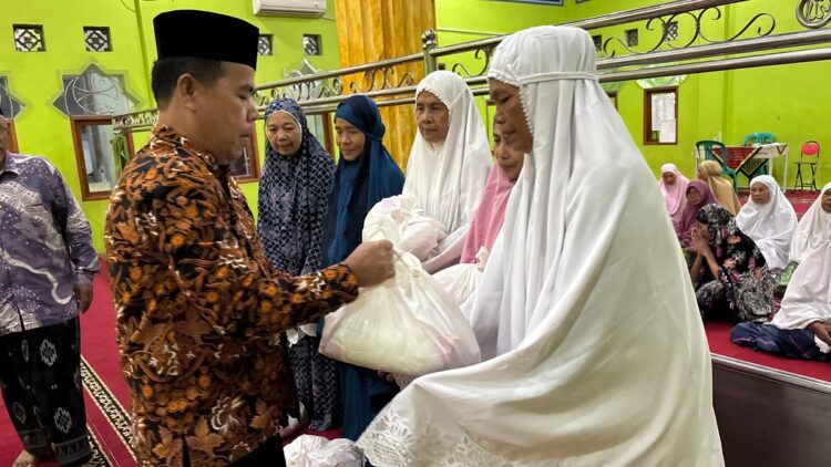 Ketua RW IV Kampung Berok, Zulkifli menyerahkan paket sembako dari Andre Rosiade kepada jamaah Masjid Arafah di acara Subuh Berkah, Jumat (28/2/2025). (Foto: Ist)