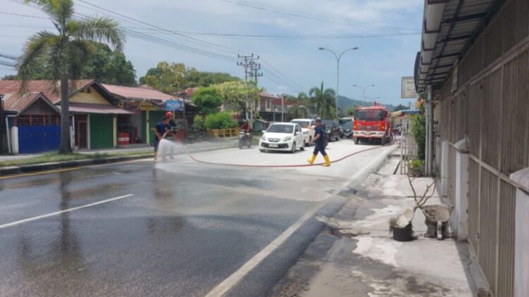 Pembersihan material jalan Padang-Solok di kawasan Cengkeh yang berdebu oleh Damkar Padang. (dok. Damkar Padang)
