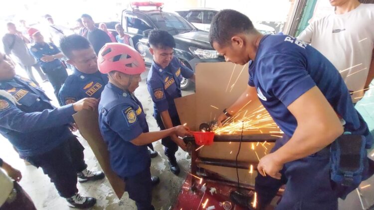 Petugas Damkar Kota Padang mengeluarkan tangan bocah yang tersangkut pipa besi. (dok. istimewa)