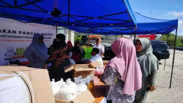 Pemkab Agam Gelar 12 Kali Pasar Murah Antisipasi Kenaikan Harga Selama Ramadhan 1 Pengunjung sedang melakukan transaksi dengan petugas saat gerakan pasar murah di halaman Dinas Ketahanan Pangan dan Perikanan Agam, Rabu (26/3). Dok Antara/Yusrizal