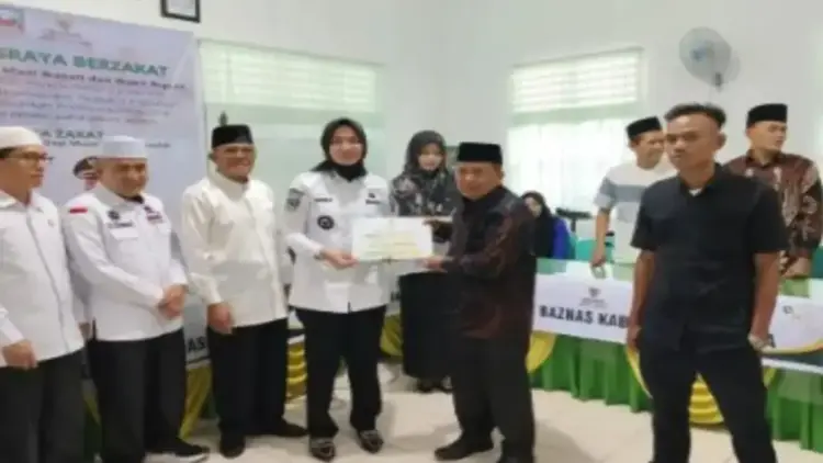 Bupati Dharmasraya Ajak Masyarakat Salurkan Zakat Lewat Baznas untuk Kesejahteraan Umat 1 Bupati Annisa Suci Ramadhani (kiri) saat menyerahkan zakat di gerai Zakat Baznas Dharmasraya, Kamis (27/3). (Antara/HO-Kominfo Dharmasraya)