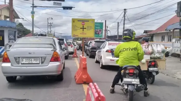 Penerapan One Way Hari Pertama di Sumbar Terdeteksi Padat dan Lancar 1 Sejumlah kendaraan melaju lambat di persimpangan Padang Luar, Kabupaten Agam saat pemberlakuan rekayasa lalu lintas, Minggu (30/3/2025). (dok. ANTARA/Muhammad Zulfikar)