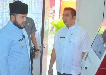 Wako Padang Fadly Amran dan Kadis Dukcapil Padang Teddy Antonius saat mengecek mesin anjungan Dukcapil Mandiri di kantor Disdukcapil Kota Padang. (dok. Prokopim)