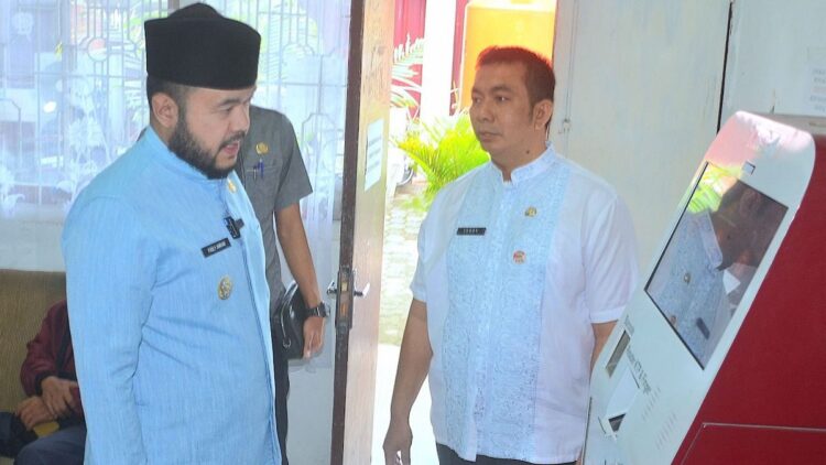 Wako Padang Fadly Amran dan Kadis Dukcapil Padang Teddy Antonius saat mengecek mesin anjungan Dukcapil Mandiri di kantor Disdukcapil Kota Padang. (dok. Prokopim)