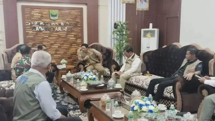 Warga Ulakan Tapakis Kompak Tangani Banjir, Kepala BNPB: Ini Contoh Kolaborasi Hebat 1 Kepala Badan Nasional Penanggulangan Bencana (BNPB) Letjen TNI Suharyanto (tengah) mendengarkan Bupati Padang Pariaman, Sumbar John Kenedy Azis yang mengekspos kegiatan gotong royong mitigasi bencana di Ulakan Tapakis pada rapat koordinasi di ruangan bupati setempat, Kamis. ANTARA/Aadiaat M. S.