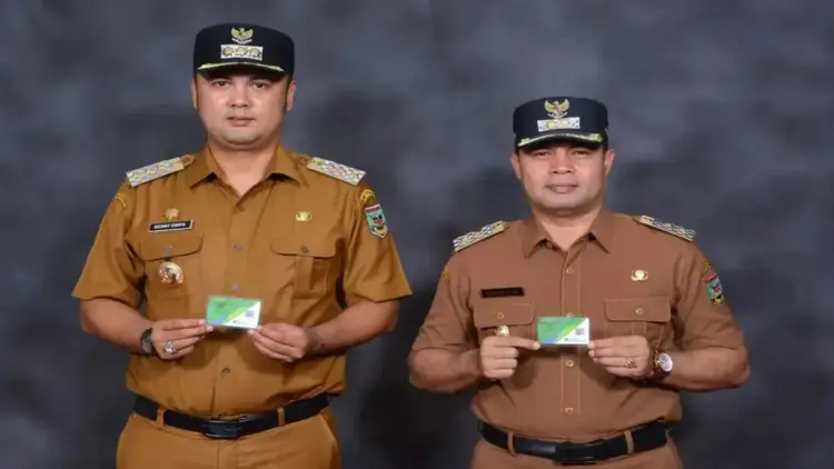Sijunjung jadi Pelopor di Sumbar, Lindungi Ribuan Pekerja Rentan Lewat BPJamsostek 1 Bupati Kabupaten Sijunjung Benny Dwifa Yuswir didampingi Wakil Bupati Irradatillah memperlihatkan kartu kepesertaan BPJS Ketenagakerjaan