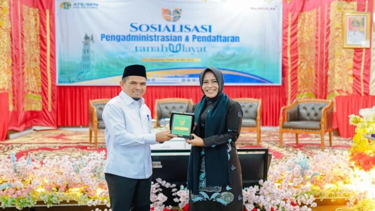 Bupati Solok Candra saat menyerahkan cendramata ke Staf Khusus Bidang Reforma Agraria Kementerian ATR/BPN, Rezka Oktoberia usai kegiatan sosialisasi pendaftaran tanah ulayat di Gedung Pertemuan Solok Nan Indah. ANTARA/HO-Diskominfo Solok.