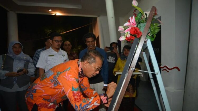 Kepala Dinas Kebudayaan Sumatera Barat, Jefrinal Arifin menandatangani poster tanda dibukanya Pameran Seni Rupa Nasional Lentera Masa karya guru di Galeri Taman Budaya Sumatera Barat di Padang, Rabu. ANTARA FOTO/Iggoy el Fitra