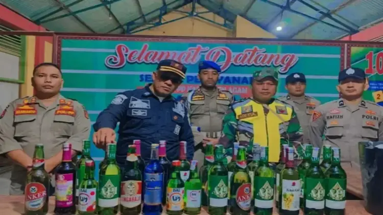 Satpol PP Agam Sita 30 Botol Miras dan 35 Liter Tuak dalam Operasi Pekat 1 Kepala Bidang Ketertiban Umum dan Ketentraman Masyarakat Satpol PP Damkar Agan Yul Akmar sedang melihat minuman keras yang disita ke Mako Satpol PP Damkar itu. Dok ANTARA/HO/Satpol PP Damkar Agam