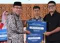 Wawako Maigus Nasir menyerahkan bantuan KUR Bank Nagari untuk konten kreator dan pengusaha muda Rico Minanglipp dengan usaha Warunk Naras. (dok. Prokopim)