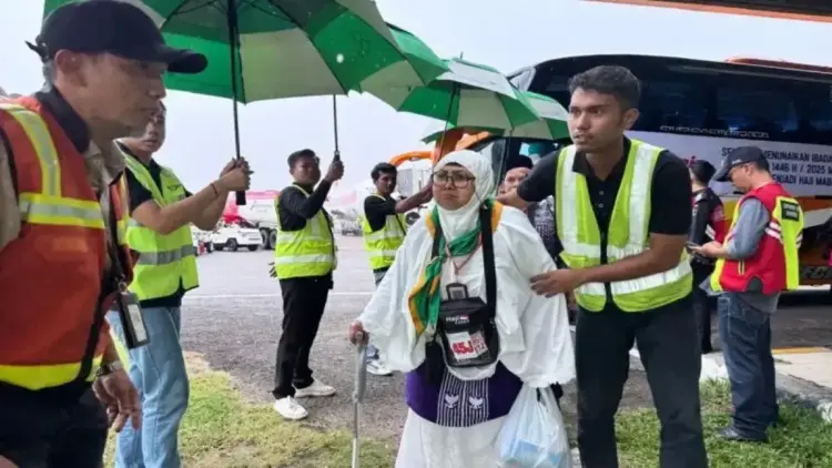 Kemenkes Imbau Jamaah Haji Kurangi Aktivitas di Luar Hotel, Waspadai Cuaca Ekstrem di Tanah Suci 1 Petugas membantu calon jamaah haji untuk menaiki pesawat di Bandara Internasional Minangkabau, Kabupaten Padang Pariaman, Sumatera Barat. Antara/HO-Humas Kemenag Sumbar