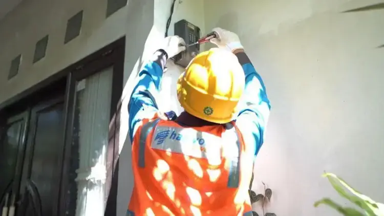 Ilustrasi Petugas PLN saat melakukan penambahan daya pada kWh meter milik pelanggan. (dok. istimewa)