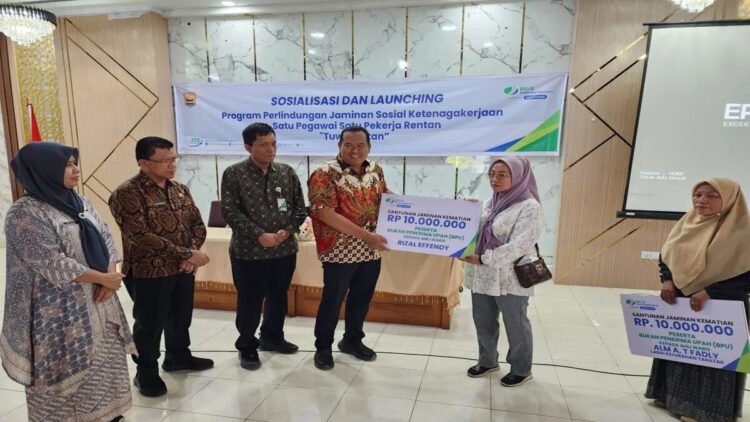 Wali Kota Pariaman, Sumbar Yota Balad (tengah) didampingi secara Kepala Kantor Cabang BPJS Ketenagakerjaan Pariaman, Herry Asmanto (tiga kiri) secara simbolis menyerahkan santunan kematian peserta BPJS Ketenagakerjaan kepada ahli waris di saat peluncuran program Tuwai Ketan di Pariaman, Kamis. Antara/HO-BPJS Ketenagakerjaan