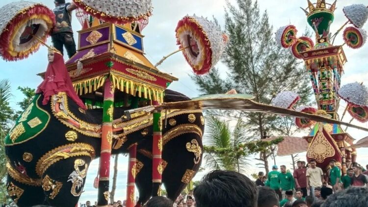 Kemenbud Kaji Tradisi Tabuik Pariaman untuk Diajukan ke UNESCO 1 Pengunjung dan anak Tabuik berada di dekat dua ornamen Tabuik yang akan dilarung ke laut pada puncak Pesona Hoyak Tabuik Piaman 2025 di Kota Pariaman, Sumbar, Minggu. ANTARA/Aadiaat M. S.
