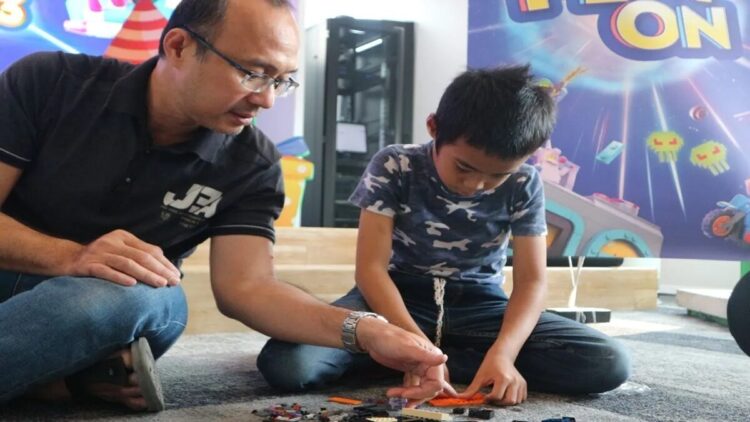 Seorang ayah mendampingi anak laki-lakinya yang sedang bermain, di Tokopedia Tower, Jakarta, Sabtu (23/9/2023) (ANTARA/Pamela Sakina)