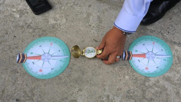 Kepala Kantor Kementerian Agama (Kemenag) Aceh Barat Abrar Zym (tengah) mengatur posisi kompas saat mengajarkan cara mengukur arah kiblat kepada siswa-siswi dengan menggunakan benda tegak lurus pada fenomena Rashdul Kiblat atau Istiwa A'zam, di Madrasah Aliyah Negeri (MAN) 1 Aceh Barat, Aceh, Selasa (27/5/2025). ANTARA FOTO/Syifa Yulinnas/bar