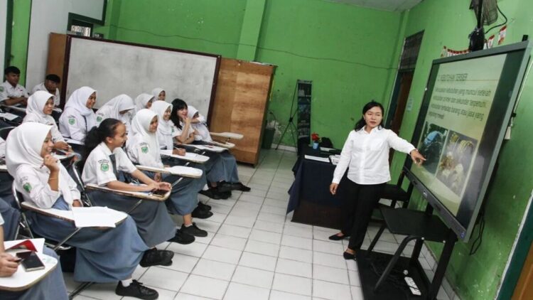 Guru menyampaikan materi pembelajaran menggunakan smart board atau papan tulis interaktif kepada siswa saat kegiatan belajar mengajar di SMKN 3 Palangka Raya, Kalimantan Tengah, Selasa (27/5/2025). ANTARA FOTO/Auliya Rahman/bar (ANTARA FOTO/AULIYA RAHMAN)