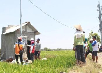 Salah satu petani di Desa Sukorejo, Ponorogo, Jawa Timur mendengarkan penjelasan dari Petugas PLN terkait penggunaan kWh meter untuk mengontrol listrik pompa air persawahan melalui program Electrifying Agriculture (EA). (dok. Humas PLN)
