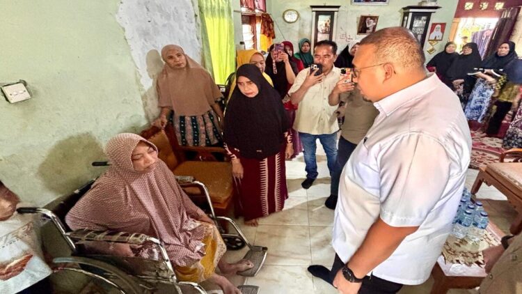 Andre Rosiade menyerahkan bantuan kepada wanita penderita pengeroposan tulang di Padang. (Foto: Ist)