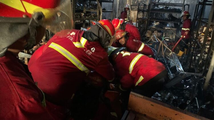 Petugas Damkar Padang mengevakuasi jenazah pemilik ruko yang tak bisa menyelamatkan diri saat kebakaran terjadi. (dok. Damkar Padang)