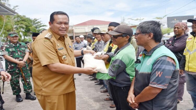 Peduli Ekonomi Warga, Pemko Pariaman Bagikan Beras untuk Tukang Ojek 1 Wako Pariaman Yota Balad menyerahkan bantuan beras gratis ke tukang ojek. (Foto: Ist)
