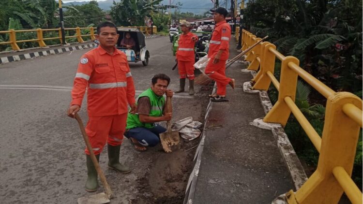 Petugas LPS Kurao Pagang membersihkan sampah di sepanjang jalan utama. (Foto: Ist)