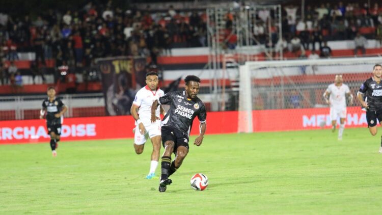 Cornelius Steward membawa bola melewati Yakob Sayuri